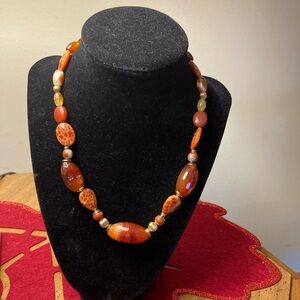 This is a Carnelian gemstone beaded necklace with gold-tone clasp.